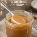 Un pot de caramel à tartiner fait maison avec une cuillère à proximité.