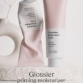 Une femme souriante appliquant un soin hydratant sur son visage, montrant une peau lumineuse et éclatante.
